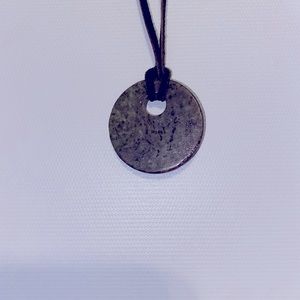 Green and black pendant on leather necklace